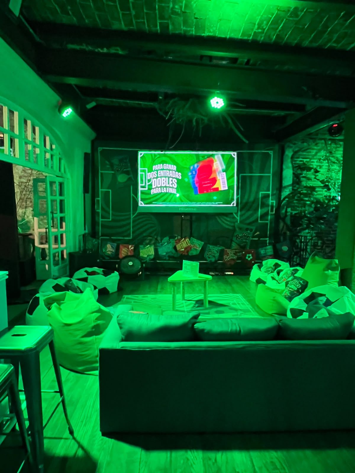 Sala principal del Palco Ruffles con pantalla gigante para ver los partidos del Mundial 2026, sofás y puffs con forma de balón.