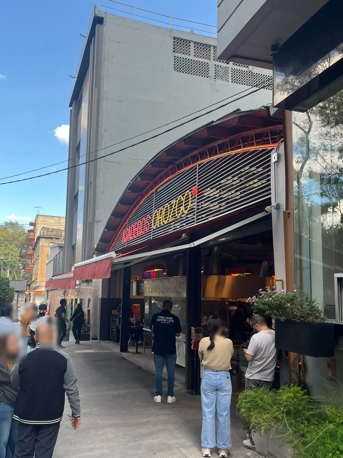 Fachada de Asaderos Orozco en Av. Álvaro Obregón 34, Roma Norte, con su letrero curvo y gente en la banqueta