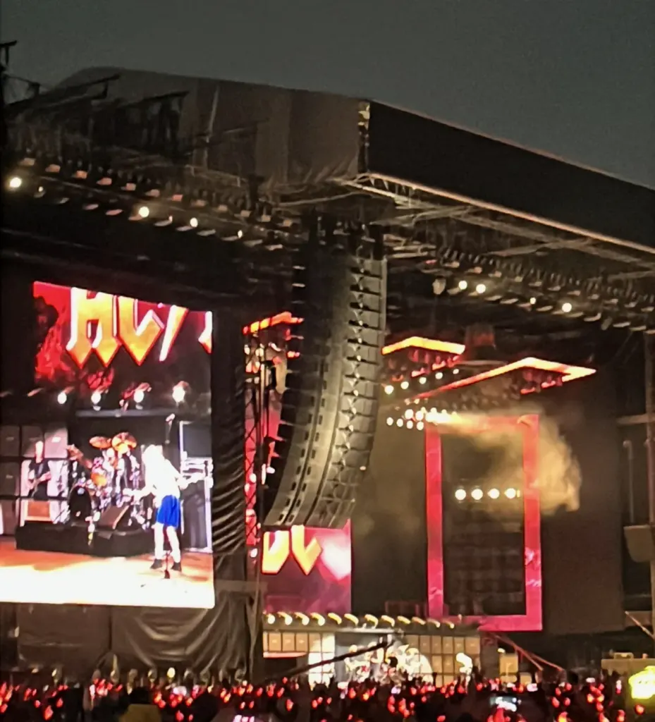 Escenario del concierto de AC/DC en el Estadio GNP Seguros con pantallas y público con diademas de cuernos rojos