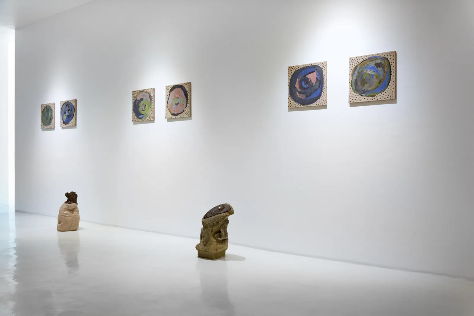 Cerámicas de James Brown en el piso y platos pintados en la pared de Galería Hilario Galguera
