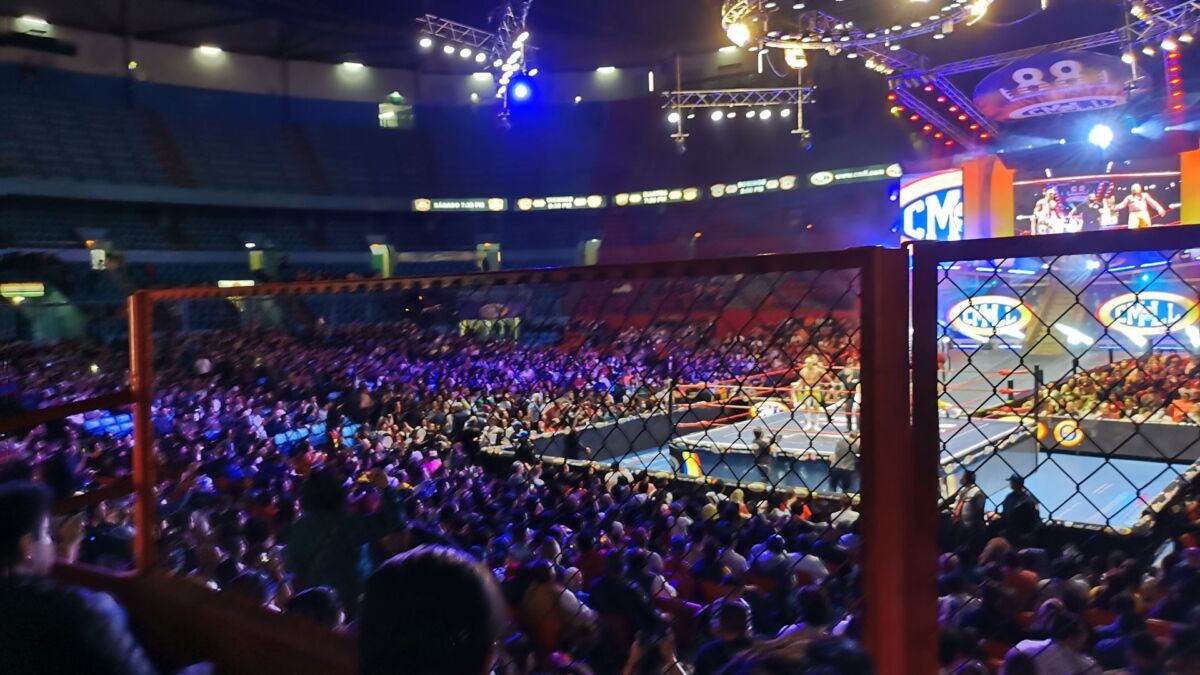 Lucha libre en el ring de la Arena México con el público alrededor
