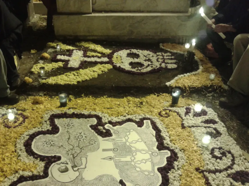 Tumbas del panteón de Míxquic adornadas con pétalos de cempasúchil, flores y veladoras durante la noche de Día de Muertos
