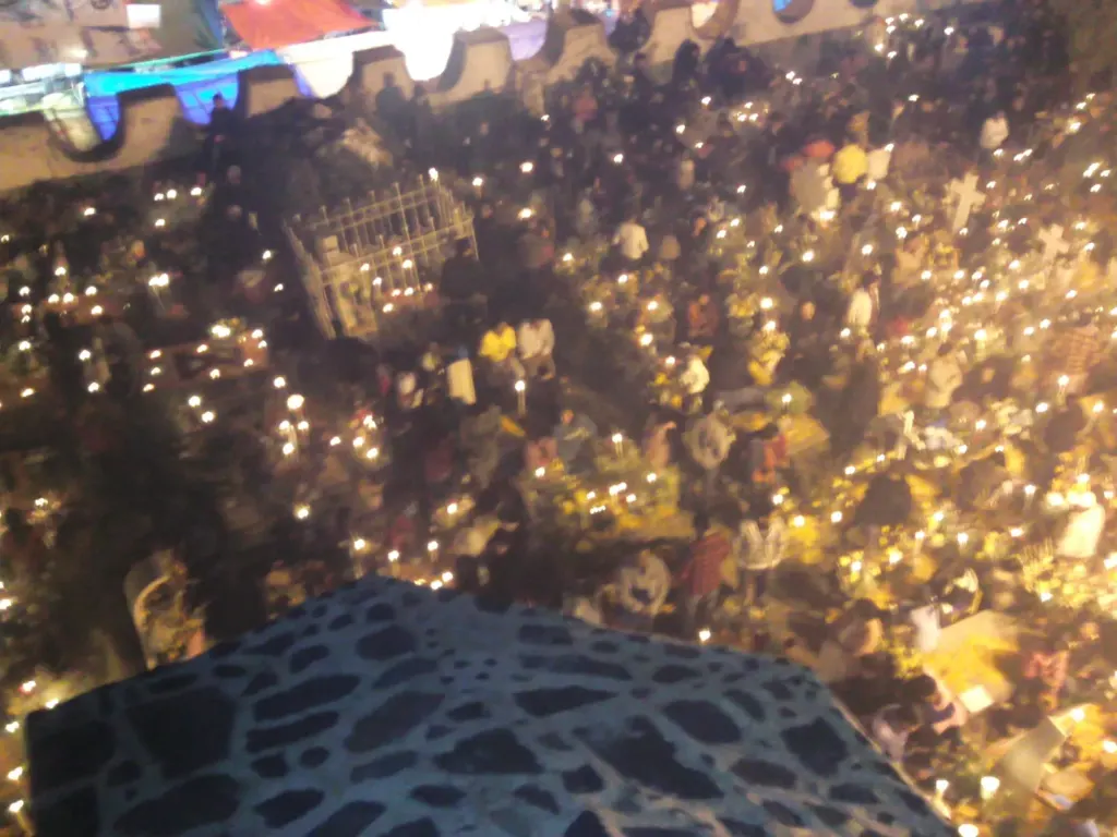 Vista nocturna del panteón de Míxquic lleno de veladoras encendidas durante La Alumbrada de Día de Muertos