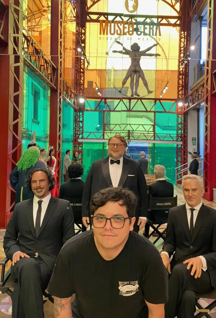 Vestíbulo del Museo de Cera de la Ciudad de México con estructura de acero rojo, vitrales de colores y el letrero del museo arriba, con figuras de cera de directores de cine al frente