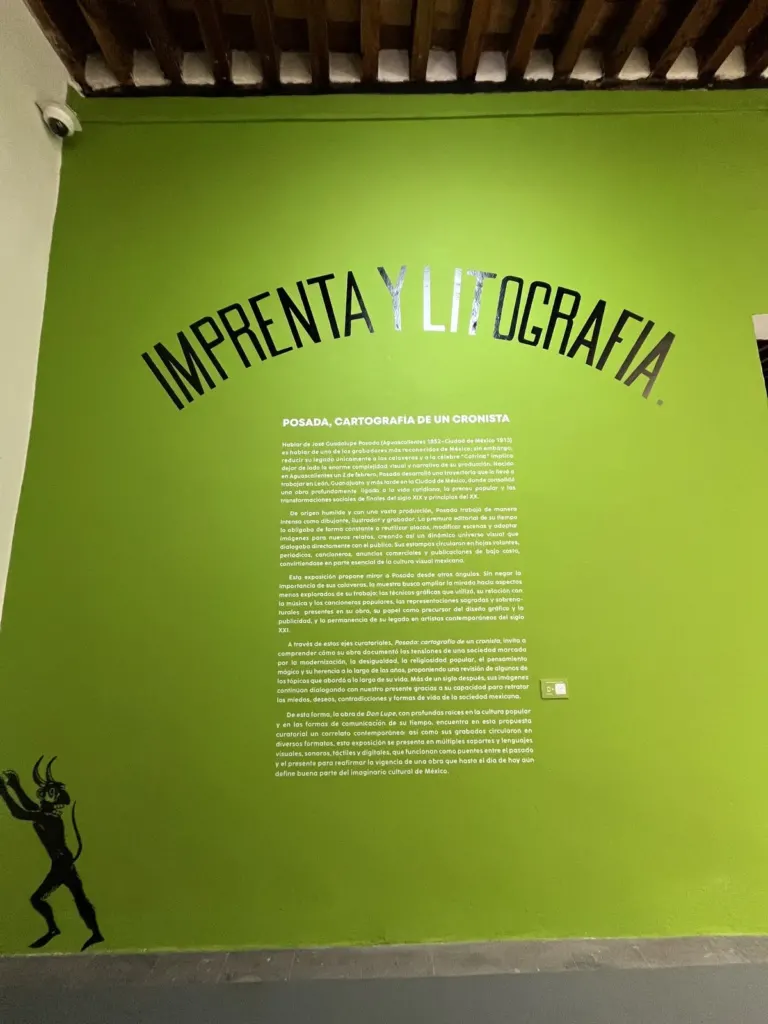 Muro verde con el título Imprenta y litografía en letras negras y el texto de sala de la exposición Posada, cartografía de un cronista