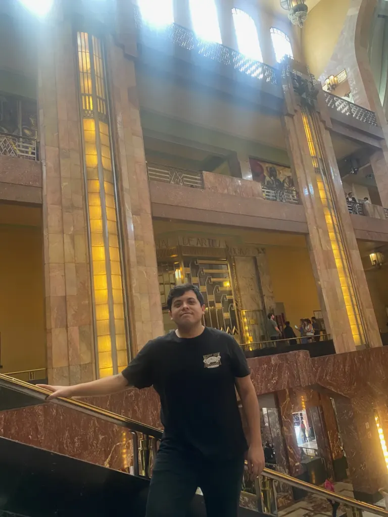 Vestíbulo del Palacio de Bellas Artes con columnas de mármol, lámparas doradas y la cúpula de vitral al fondo, febrero de 2024