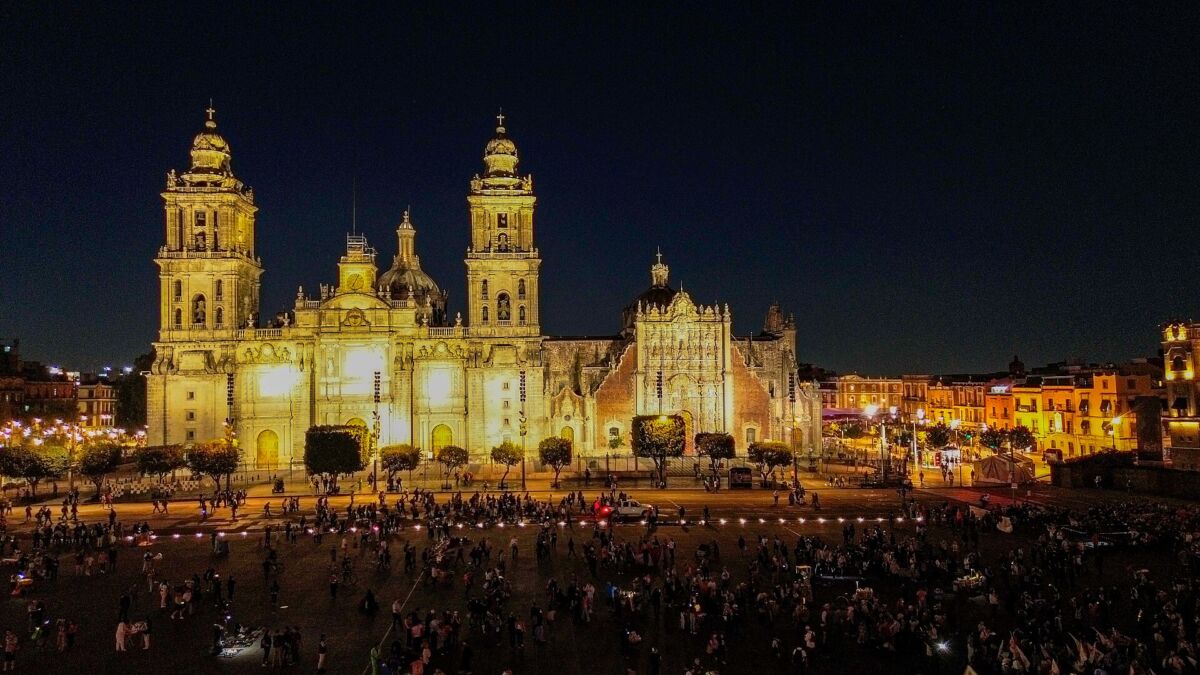 Vista aérea nocturna de la Catedral Metropolitana de la Ciudad de México iluminada frente al Zócalo