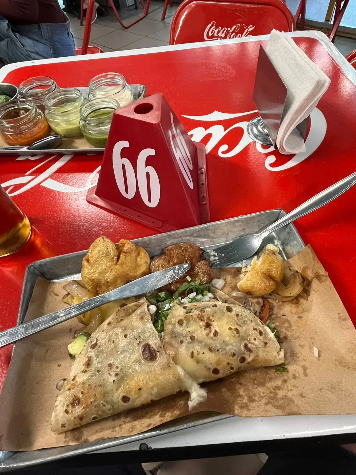 Gringa de trompo con queso, cilantro y cebolla sobre charola de Taquería Orinoco, con salsas al fondo