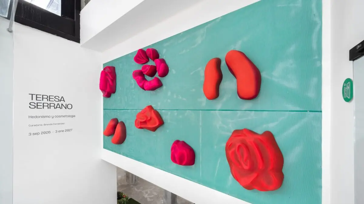 Muro turquesa con esculturas de rosas y labios en rojo y rosa de Teresa Serrano y el rotulo de la exposicion Hedonismo y cosmetologia en Galeria Ana Tejeda