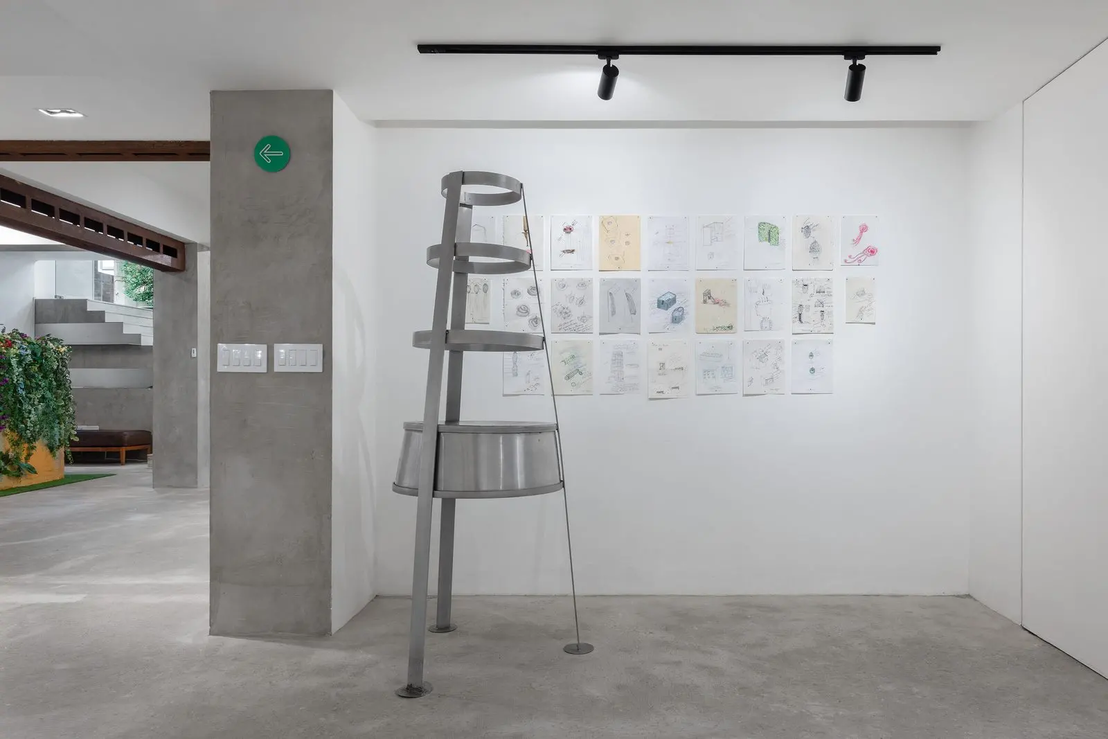Escultura metalica en espiral junto a un muro de bocetos preparatorios de Teresa Serrano en Galeria Ana Tejeda