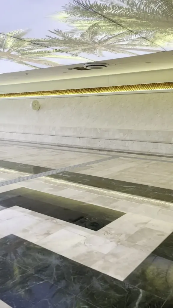 Interior del aeropuerto de Tulum con techo de palmeras y piso de mármol
